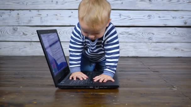 Krásné jeden rok staré dítě hraje s přenosným počítačem. obchodní koncepce — Stock video
