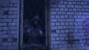 üzgün evsiz adam pencereden görünüyor