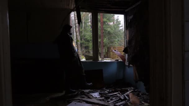 Одинокие домохозяйки ищут что-то в заброшенном здании — стоковое видео