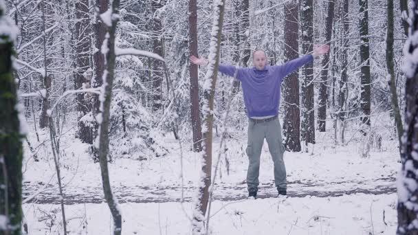 Atleta masculino calentándose en el bosque de invierno. Concepto de inspiración y motivación al aire libre . — Vídeos de Stock