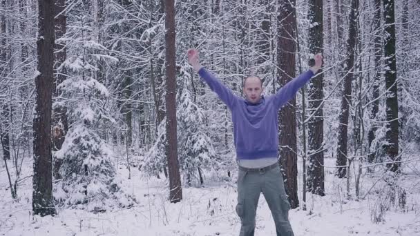 Atleta masculino calentándose en el bosque de invierno. Concepto de inspiración y motivación al aire libre . — Vídeo de stock