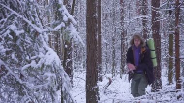 Adam ve kadın çift kartopu birbirleriyle birlikte bir kar kış ormanda atıyor. genç adam ormandaki kartopu oynuyor