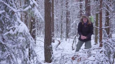 Adam ve kadın çift kartopu birbirleriyle birlikte bir kar kış ormanda atıyor. genç adam ormandaki kartopu oynuyor