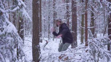 Adam ve kadın çift kartopu birbirleriyle birlikte bir kar kış ormanda atıyor. genç adam ormandaki kartopu oynuyor