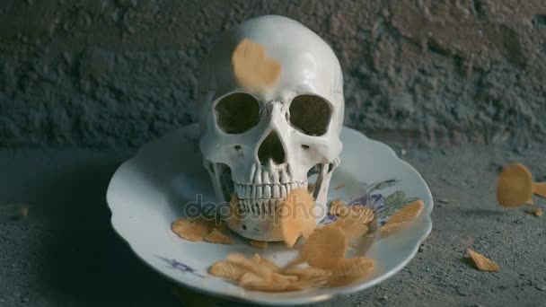 The concept of harmful junk food. Skull and falling chips. Slow motion. — Stock Video