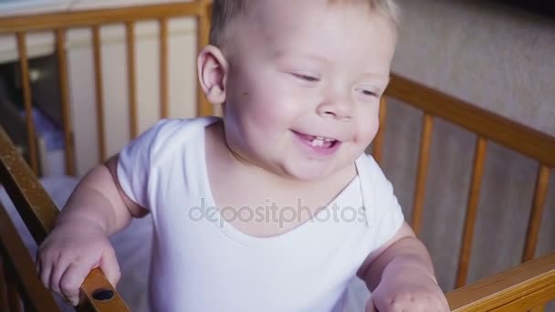 周りベビーベッド ルックスの子供を話す、ジャンプし、笑顔. — ストック動画