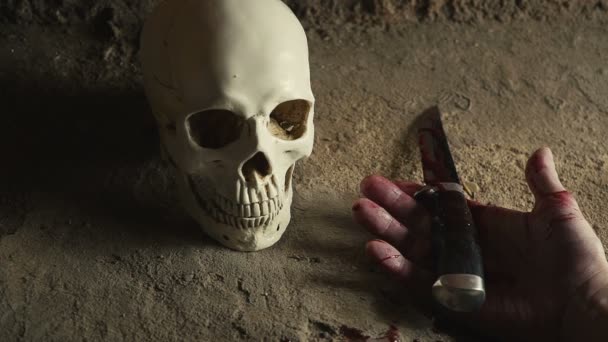 頭蓋骨の背景にナイフでキラー マニアック。血まみれの手。殺害の概念 — ストック動画