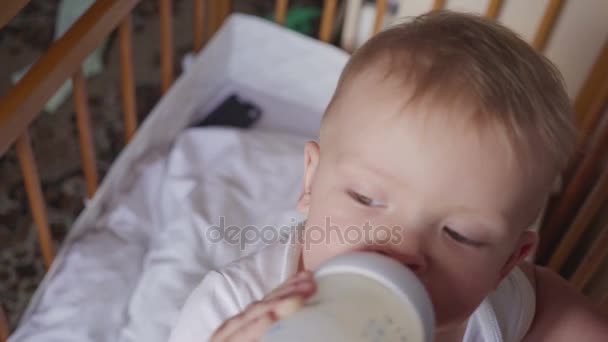 Bambino sorridente in piedi e che beve latte da una bottiglia — Video Stock