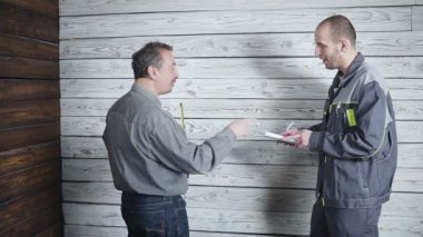 işçi ve zorlu müşteri tartışmak ve ahşap duvar arka plan yemin ederim. Sorun İnşaat.