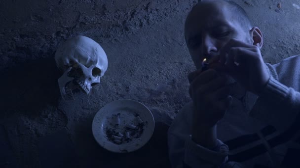 Концепция курения убивает, портрет курильщика на фоне черепа — стоковое видео