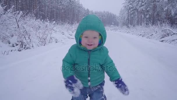 Alegre menino de um ano na estrada da floresta de inverno. criado com gimbal — Vídeo de Stock