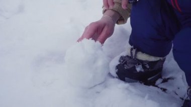 Anne ve oğlu kar ile oynuyor. Eller yakın çekim