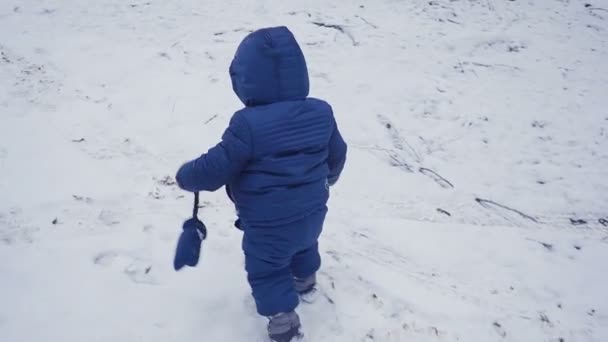 Веселий однорічний хлопчик у зимовому лісі. створено з гільзою — стокове відео