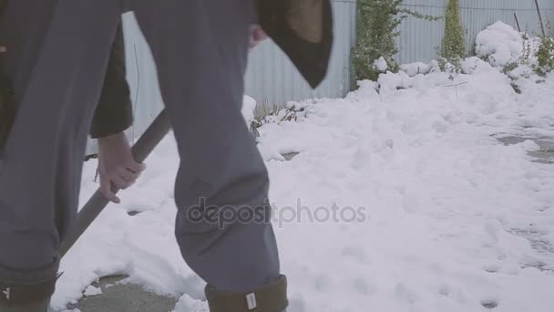 Trabaja después de la noche nevada. Hombre con una pala quitando la nieve de su patio en una fría mañana nevada — Vídeo de stock