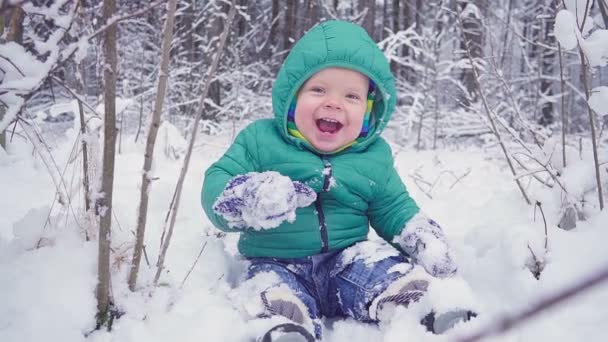 Alegre niño de un año está sentado en el bosque de invierno y se ríe. creado con gimbal — Vídeo de stock
