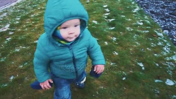 Le printemps. Steadicam shot of kid running down the sidewalk, grass and melting snow. au ralenti — Video