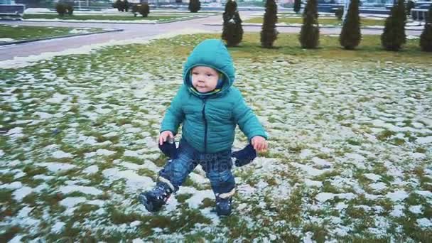Primavera. Colpo Steadicam di bambino che corre lungo il marciapiede, erba e neve che si scioglie. rallentatore — Video Stock