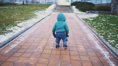 Bahar. kaldırım, çim ve eriyen kar çalışan çocuk.