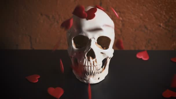 Crâne humain au cœur rouge. Les coeurs tombent sur le crâne au ralenti. Concept pour la Saint-Valentin. Sida — Video