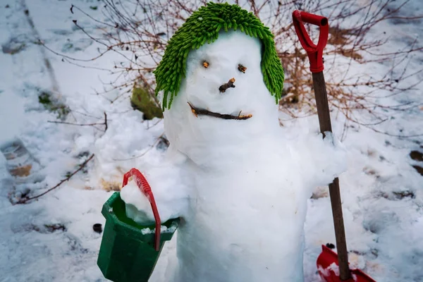 Le bonhomme de neige souriant mignon sur sa casquette verte — Photo