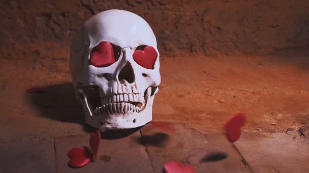 Menschlicher Schädel mit rotem Herzen. Herzen fallen auf den Schädel in Zeitlupe. Konzept zum Valentinstag. Hilfsmittel — Stockvideo