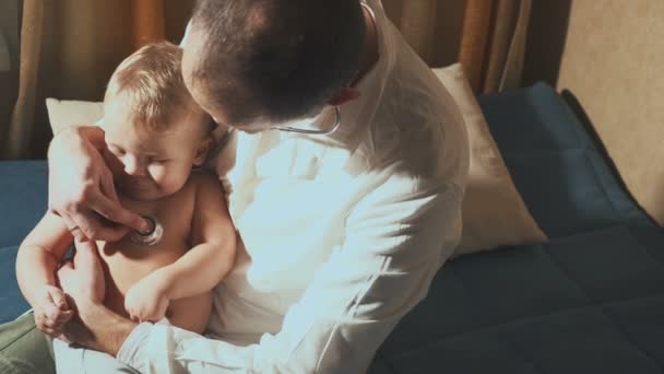 Der Arzt besucht den Säugling zu Hause. Baby mit Stethoskop — Stockvideo