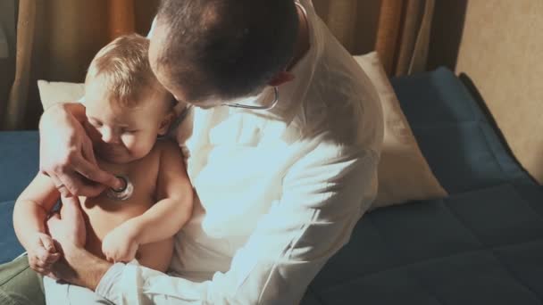 Le médecin rend visite au bébé patient à la maison. Bébé avec stéthoscope — Video