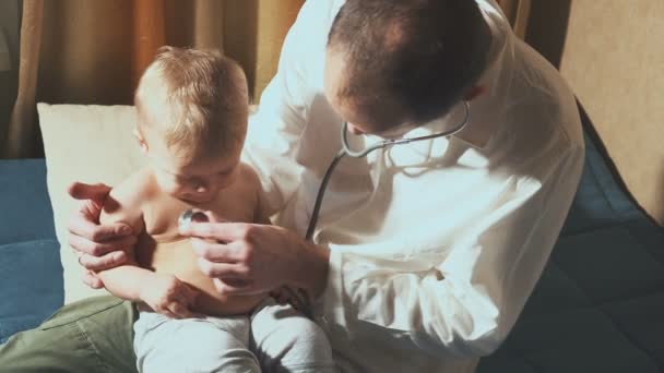 De dokter bezoeken de baby patiënt thuis. Baby met de stethoscoop — Stockvideo