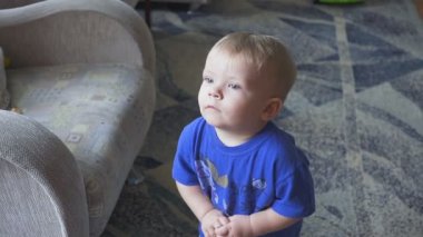 Bir yaşındaki çocuk TV - dolly atış izliyor. Küçük çocuk çizgi film odasında TV izliyor.