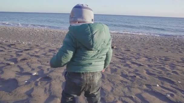 Mode de vie du bébé. Le garçon court à la mer au coucher du soleil. concept de vacances. Au ralenti. prise de vue avec stedicam — Video