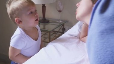 Anne bir yaşındaki oğlu odasında kızıyor. Çakışma anne ve çocuk.