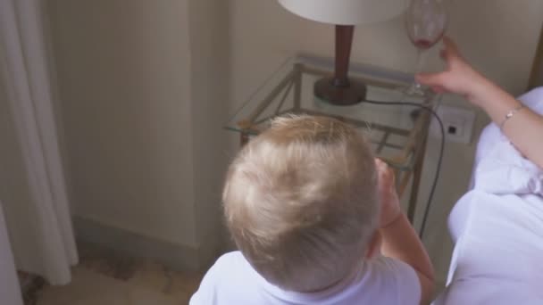 Un enfant d'un an boit du lait et sa mère du vin. Le concept d'une famille dysfonctionnelle et l'alcoolisme — Video