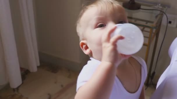 Ein ohraltes Baby trinkt seine Flasche. — Stockvideo