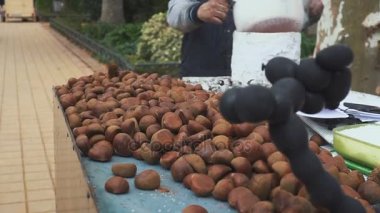 Kestane bir sokak satıcısı tarafından bir tavada kavurma. İspanya. Sevilla