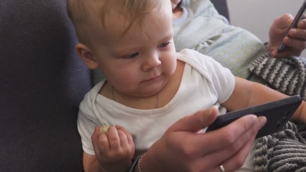 Mother and son are looking at their smartphones. Gadget addiction concept. — Stock Video