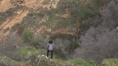 turist kayanın üzerinde durmak ve bir muhteşem dağ manzara ve mimari bak