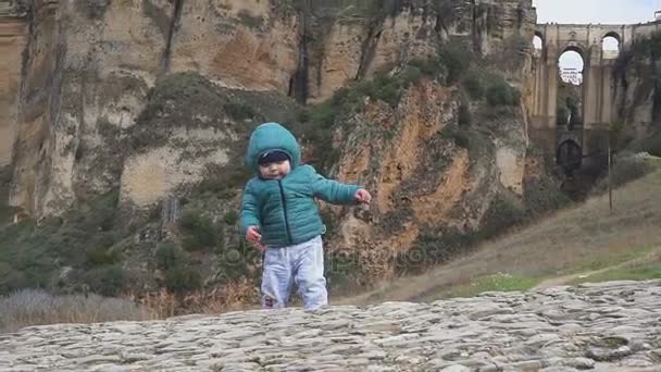 Één jaar oude baby wandelingen in de buurt van het oude kasteel van ruïnes in de bergen. Spanje. Ronda — Stockvideo