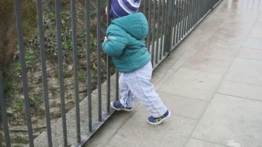 Eski Şehir'deki çocuk. Çalışan ve kafes tellerin arkasından bakıyor. Özgürlük kavramı. Portreler. İspanya. Ronda. stedicam ile vurdu