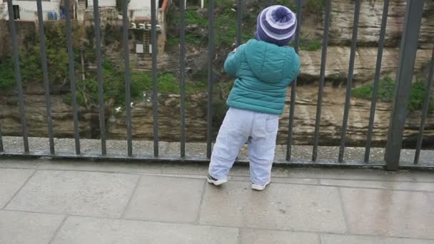 The kid in the old town. Running and looking through the trellis fence. The concept of freedom. Portraits. Spain. Ronda. shot with stedicam — Stock Video