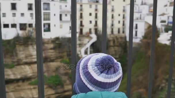 The kid in the old town. Running and looking through the trellis fence. The concept of freedom. Portraits. Spain. Ronda. shot with stedicam — Stock Video
