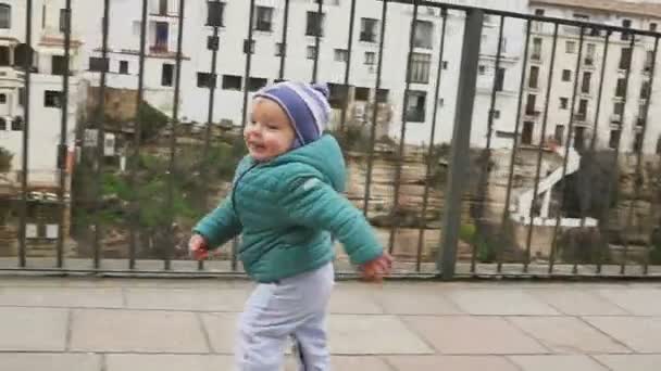 Joyful kid dança e corre em um lugar histórico. Espanha. Ronda. câmara lenta — Vídeo de Stock