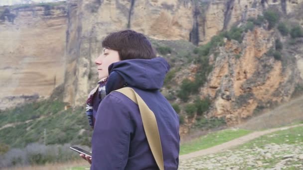 Retrato de uma jovem mulher em um fundo de uma paisagem de montanha e cidade velha — Vídeo de Stock