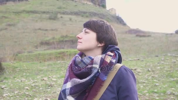 Portrait of a young woman on a background of a mountain landscape and old city — Stock Video