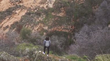 turist kayanın üzerinde durmak ve bir muhteşem dağ manzara ve mimari bak
