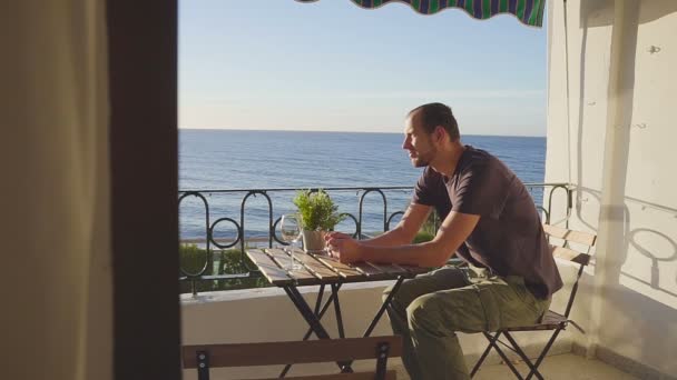 Man in looks at the ocean from a balcony on Nerha. Spain. — Stock Video
