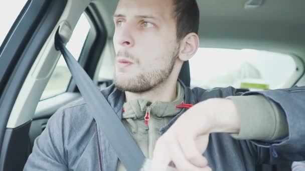 Молодой человек ест оливки в машине — стоковое видео