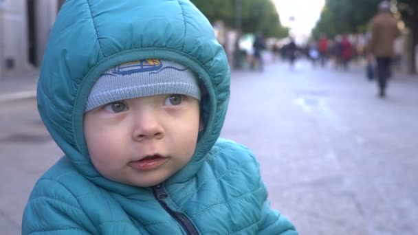 Steadicam снимок грустного маленького мальчика на тротуаре, замедленное движение — стоковое видео