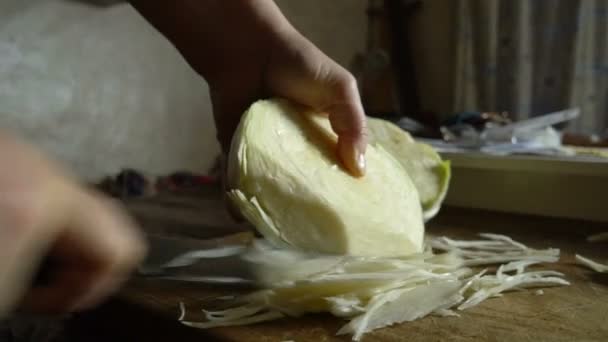 Жіночі руки вирізають зелений салат з ножем на дерев'яній дошці. Впритул ніж розрізає овочі на салат. Закритий ніж вирізає свіжу капусту для вегетаріанського салату. Приготування овочевого салату — стокове відео