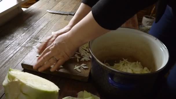 As mãos das mulheres estão cozinhando uma salada verde na tábua de madeira. Preparação de salada vegetal — Vídeo de Stock