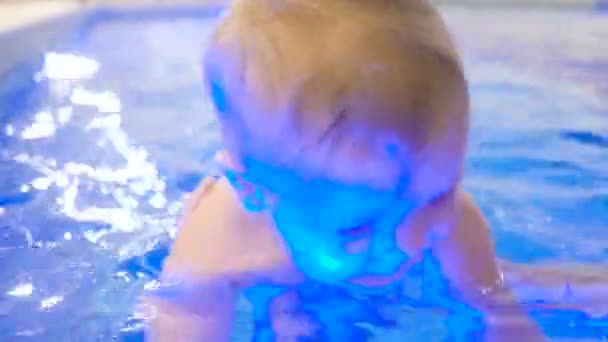 En ung mamma med en pojke simmar och har kul i poolen. Glad liten pojke simning i poolen tillsammans med sin mor — Stockvideo